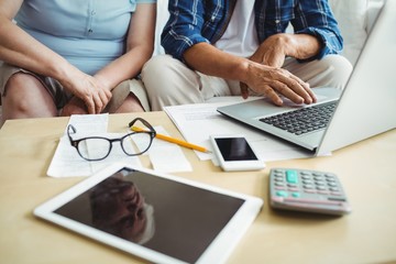 Mid-section of senior couple using laptop