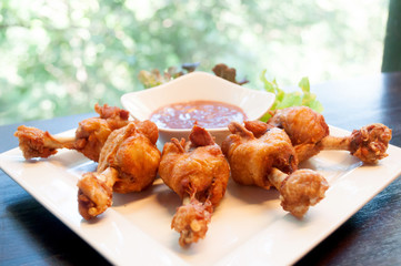 deep fried chicken tendons and sauce on white dish with wooden background,selective focus
