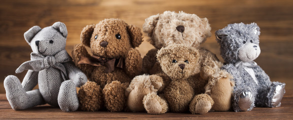 Group of cute teddy bears on vintage wooden background