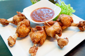 deep fried chicken tendons and sauce on white dish with wooden background,selective focus