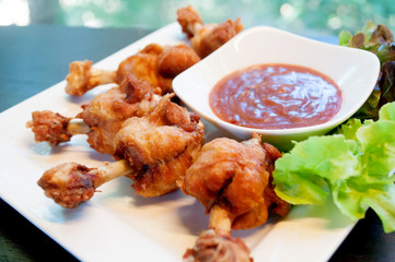 deep fried chicken tendons and sauce on white dish with wooden background,selective focus