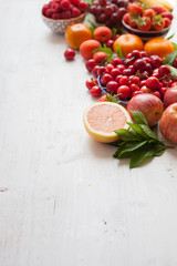Summer fruits and berries on a white table, with space for text, selective focus