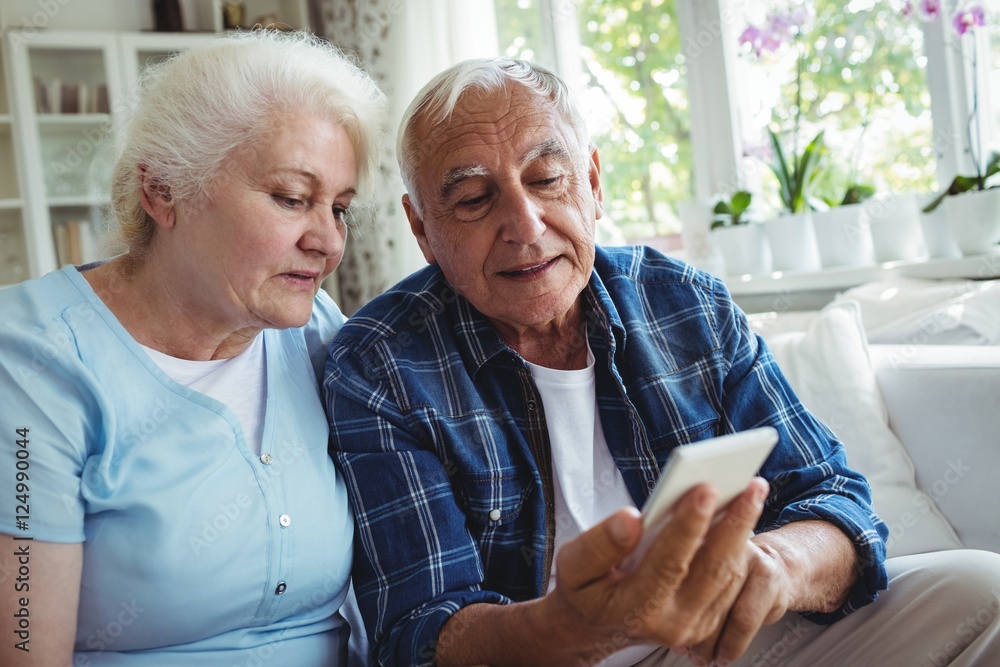 Wall mural senior couple using mobile phone