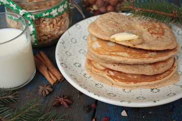 Christmas pancakes from whole wheat flour with chocolate and butter, nuts, muesli, milk. nutritious, healthy, festive Breakfast