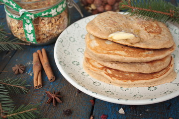 Christmas pancakes from whole wheat flour with chocolate and butter, nuts, muesli, milk. nutritious, healthy, festive Breakfast