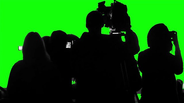 Crowd of cameramen, reporters, photographers shooting an event on a green screen