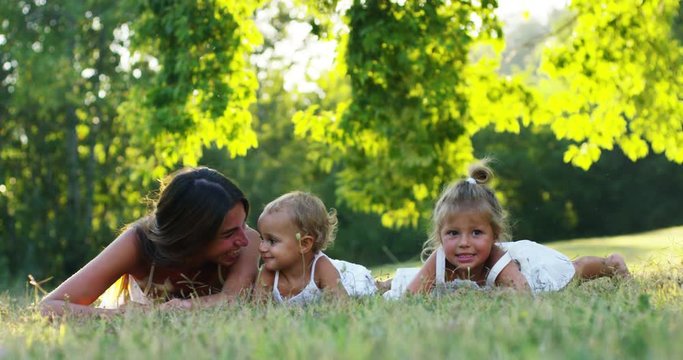 mother with little girls dressed in a vintage lawn play round dance near tree in sunset happy little girl in nature.  concept of nature and sustainability, connection with nature and the green world.