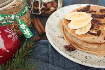 Christmas pancakes from whole wheat flour with chocolate and butter, nuts, muesli, milk. nutritious, healthy, festive Breakfast