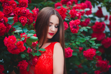 Beautiful portrait of sensual brunette young woman close to red roses