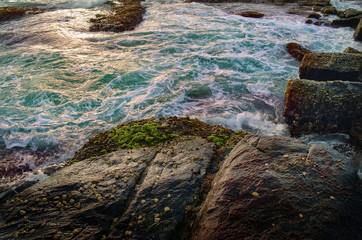 Waves breaking on the rocks forming foam