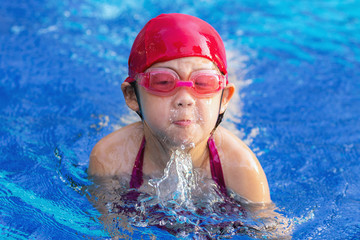 Child Swimming Breaststroke in Swimming Pool
