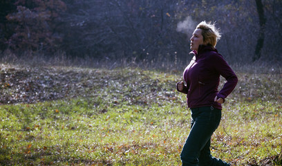 Naklejka premium Female jogger running at cold morning rising breath vapour