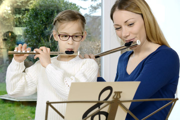 Kind lernt Querflöte spielen bei Musikunterricht mit Musiklehrer