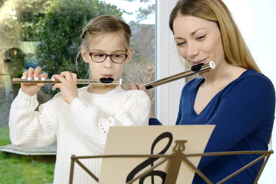 Kind lernt Querfl&ouml;te spielen bei Musikunterricht mit Musiklehrer