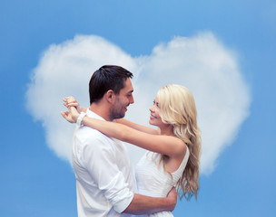 happy couple hugging over heart shaped cloud