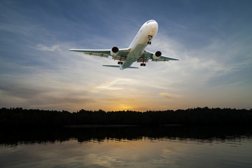 Fototapeta na wymiar Airplane flying in the sky tropical sea at sunset time.