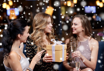 happy women with champagne and gift at night club