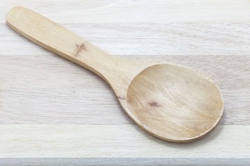 Wooden spoon on wooden background.