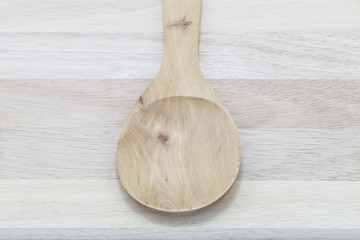 Wooden spoon on wooden background.