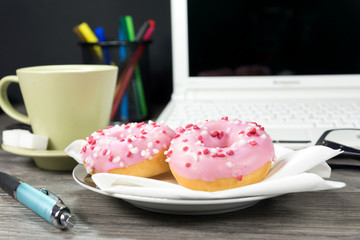 Kaffee und Donuts auf einem Bürotisch