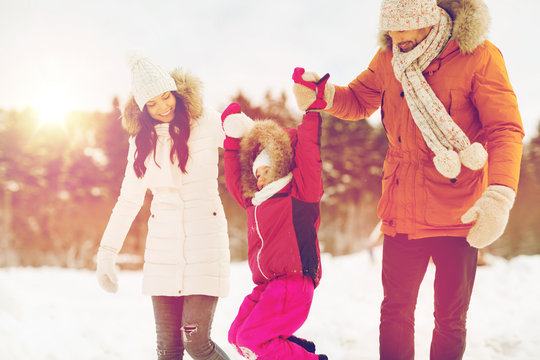 Happy Family In Winter Clothes Walking Outdoors