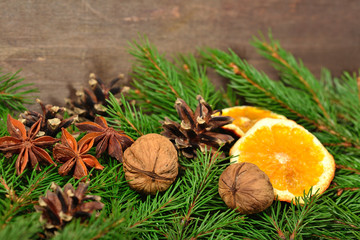 Star anise, nuts, cones, dried oranges and spruse branch on a wo