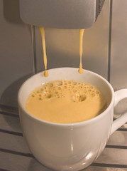Close up of espresso pouring from coffee machine. Drops splash