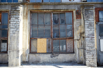 old industrial building with broken glass window