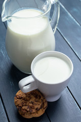 fresh milk in glass jug and glass on wooden background