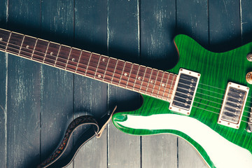 Electric guitar body and neck detail on wooden background