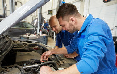 mechanic men with wrench repairing car at workshop