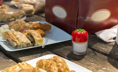 types of local turkish pastry on wooden picnic table and a salt shaker in frame