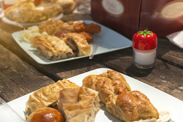 types of local turkish pastry on wooden picnic table and a salt shaker in frame