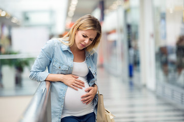 Pregnant woman touching her belly, having pains