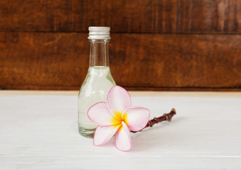 Bottle of aroma oil and plumeria flower,massage and spa concept background