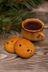 Obraz na płótnie Canvas Small cup of coffee, cookies and fir branch on wooden background