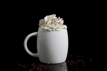 cup of hot chocolate with whipped cream on black background