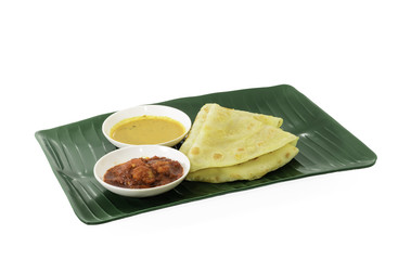 Two slices of homemade plain pancake with shrimp gravy or sambal udang on green banana leaf plate on white background
