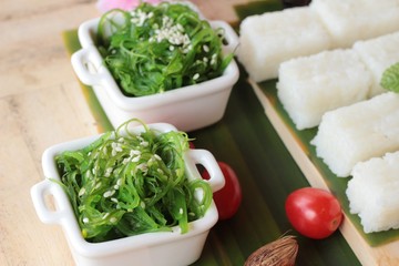 Making sushi roll and seaweed salad with rice.