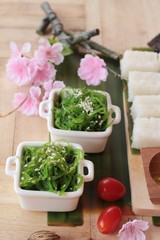 Making sushi roll and seaweed salad with rice.