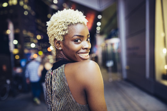 USA, New York City, smiling young woman on Times Square at night