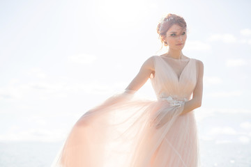Fototapeta na wymiar Portrait of beautiful bride standing by the beach at sunset