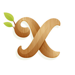 X letter logo with wood texture and green leaves.