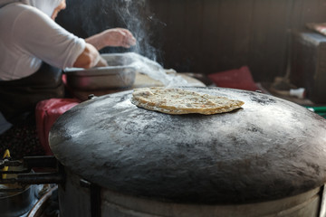 Granny chef cook Turkish pancake Gozleme on the stove