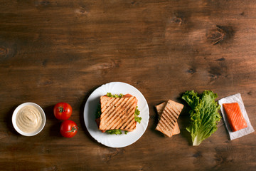 Club sandwich prepared with fish on the wooden board