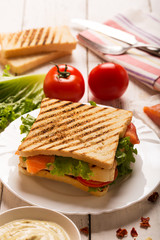 Club sandwich prepared with fish on the white wooden board