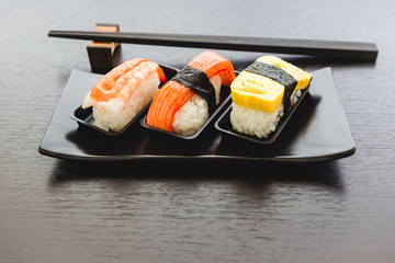 Sashimi fish, shrimp and egg set on the black plate