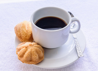 Black coffee and bread on  white towel