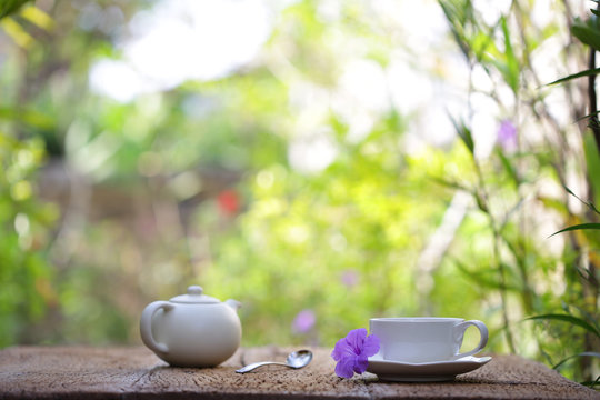 white tea cup with white teapot on wooden table