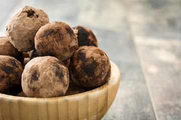  Chocolate truffles in bowl on wooden table

